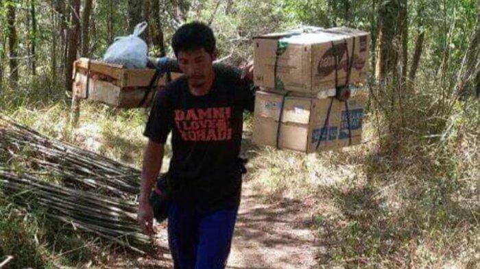 Samin saat memikul barang dagangan yang akan diantarkan ke warung di Gunung Lawu, Kabupaten Karanganyar.