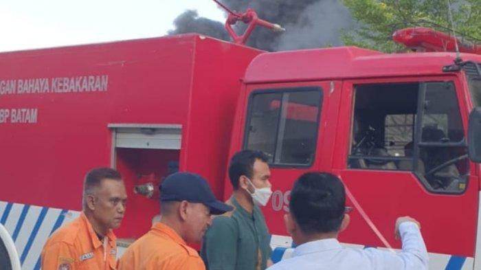 PADAMKAN API – Gubernur Kepulauan Riau, H. Ansar Ahmad membantu petugas pemadam kebakaran untuk memadamkan api yang menghanguskan sebuah bangunan kios di daerah Kabil Indah, Telaga Punggur, Kota Bata, Provinsi Kepulauan Riau, Minggu (1/5/2022) pagi.