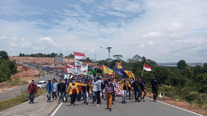 JALAN KAKI - Massa aksi dari mahasiswa berjalan kaki menuju kantor DPRD Kepri di Tanjungpinang, Selasa (13/10/2020) untuk menyuarakan aspirasi menolak UU Cipta Kerja
