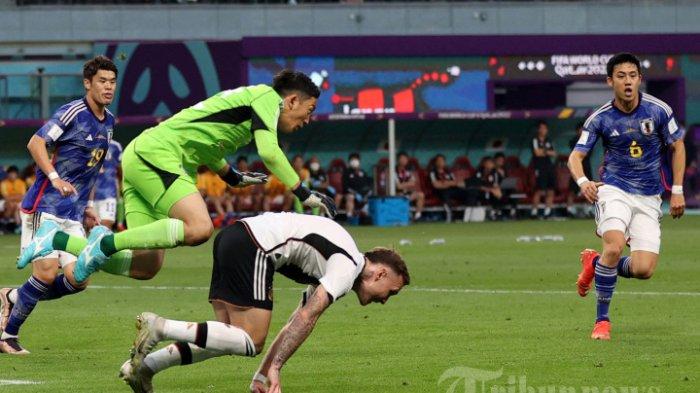 Penjaga gawang Timnas Jepang, #12 Shuichi Gonda (kiri) melanggar bek Timnas Jerman, #03 David Raum (tengah) dalam laga sepak bola Grup E Piala Dunia 2022 Qatar antara Jerman melawan Jepang di Stadion Internasional Khalifa, di Doha, Qatar, Rabu (23/11/2022) waktu setempat.