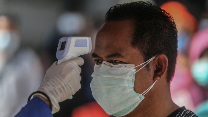 Warga diperiksa suhu tubuhnya oleh petugas