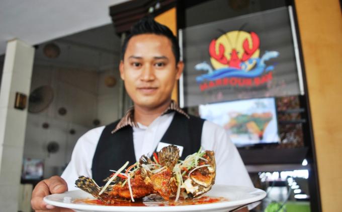 Staf Harbour Bay Seafood menunjukan menu ikan goreng ala Thai, Rabu (24/11/2013). Menu ini bisa menjadi menu pilihan bersama keluarga di akhir pekan. Menu seafood yang dihadirkan di proses dari ikan segar dengan cita rasa yang berbeda.