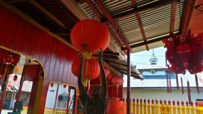 Tiau Seng Tong (54), pengurus klenteng Pu Tek Chi di Penagi mengatur letak posisi lampion untuk perayaan imlek