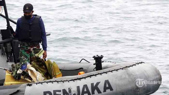 Prajurit TNI mengevakuasi serpihan dari pesawat Sriwijaya Air SJ 182 yang hilang kontak saat melakukan pencairan di perairan Kepulauan Seribu, Jakarta, Minggu (10/1/2021). Pesawat Sriwijaya Air SJ 182 yang hilang kontak pada Sabtu (9/1/2021) sekitar pukul 14.40 WIB di ketinggian 10 ribu kaki tersebut membawa enam awak dan 56 penumpang. TRIBUNNEWS/IRWAN