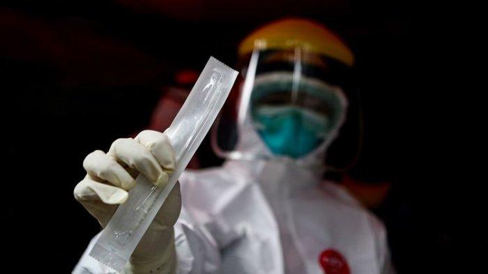 Petugas medis menunjukkan alat swab spesimen saat swab test secara drive thru di halaman Laboratorium Kesehataan Daerah (LABKESDA) Kota Tangerang, Banten, Senin (6/4/2020).