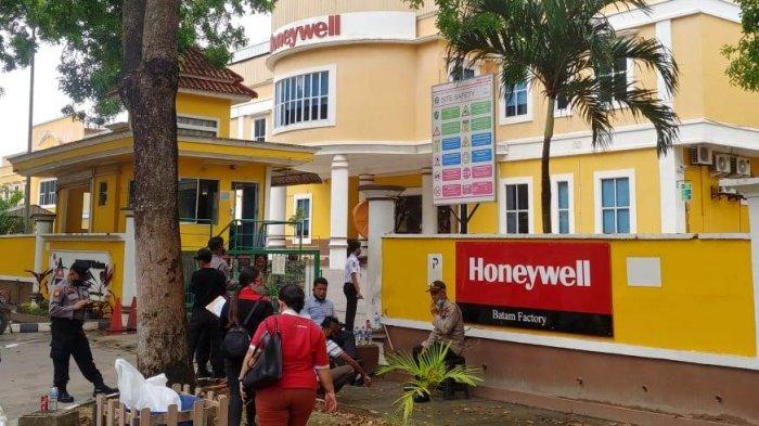 PHK PT KSW HONEYWELL BATAM - Personel kepolisian dan karyawan saat memasuki gedung PT KSW Honeywell Batam di kawasan Latrade Industrial Park, Selasa (24/11/2020). Setidaknya 400 pekerja di perusahaan ini menerima PHK.