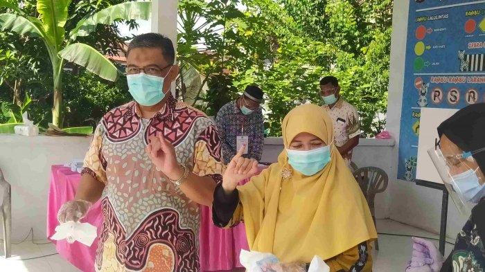 PILKADA KEPRI - Suryani bersama suami menggunakan hak pilihnya di Batam, Rabu (9/12/2020).