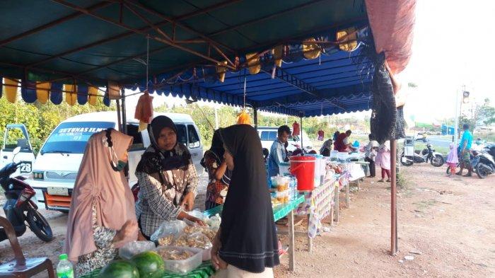 Warga membeli takji dan makanan berbuka puasa di Simpang Jalan Lintas Barat, Km 16, Toapaya Selatan, Kabupaten Bintan, Provinsi Kepri, Rabu (21/4/2021).