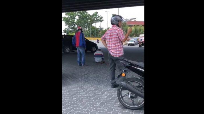 Tangkapan layar dari video orang salat di tengah jalan sampai dijaga para pengendara motor. Peristiwa ini terjadi di Malaysia pada Kamis (25/2/2021) dan viral di media sosial
