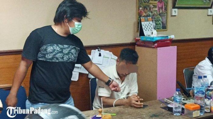 Seorang pecatan polisi saat diamankan Polresta Padang karena diduga melakukan KDRT.