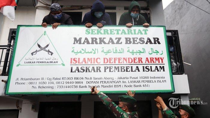 Pasukan TNI-polri berpakaian lengkap saat mencoba menurunkan atribut Front Pembela Islam (FPI) di kawasan Petamburan, Jakarta Pusat, Rabu (30/12/2020). Sebelumnya, Menko Polhukam Mahfud MD dalam jumpa pers yang didampingi sejumlah menteri dan kepala lembaga menyatakan bahwa Pemerintah melarang aktivitas FPI dan akan menghentikan setiap kegiatan FPI, karena FPI tidak lagi memiliki legal standing. keputusan tersebut tertuang dalam Surat Keputusan Bersama (SKB) 6 Pejabat Tertinggi. Mereka yang membubuhkan teken pada SK Bersama itu adalah Menteri Dalam Negeri, Menteri Hukum dan HAM, Menteri Komunikasi dan Informatika, Jaksa Agung, Kapolri, serta Kepala Badan Nasional Penanggulangan Terorisme (BNPT). Tribunnews/Jeprima