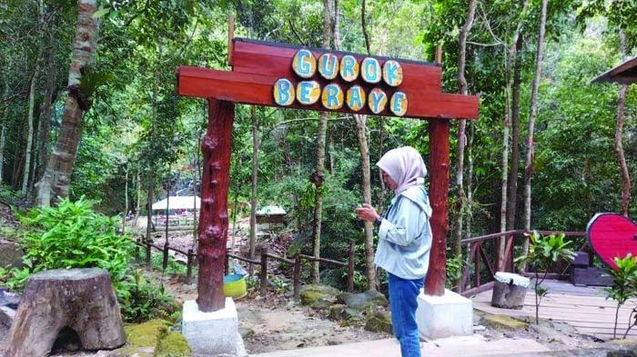 Pengunjung saat berada di gerbang kayu bertuliskan Gurok Beraye, Sabtu (6/3/2021).