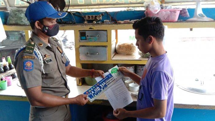 Anggota Satpol PP Belitung Timur saat menempelkan Instruksi Bupati Belitung Timur ke tempat-tempat publik di tujuh kecamatan, Selasa (6/4/2021).
