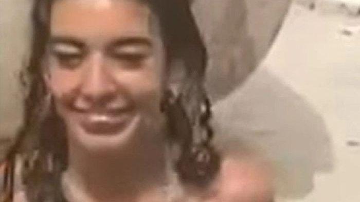 Wanita muda berenang tanpa busana di kolam taman di tengah kota