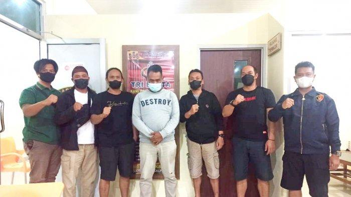 A (35) (Sweater putih) seorang buruh harian tertunduk lesu saat digelandang Tim Buru Sergap Naga Polres Pangkalpinang ke Polres Pangkalpinang, Minggu (19/9/2021) malam. (Ist/Tim Naga Polres Pangkalpinang)