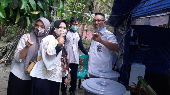 Burhanudin bersama istri dan anaknya saat melakukan pencoblosan di TPS 4 Desa mayang Kecamatan Kelapa Kampit, Belitung Timur. Rabu (9/12/2020).