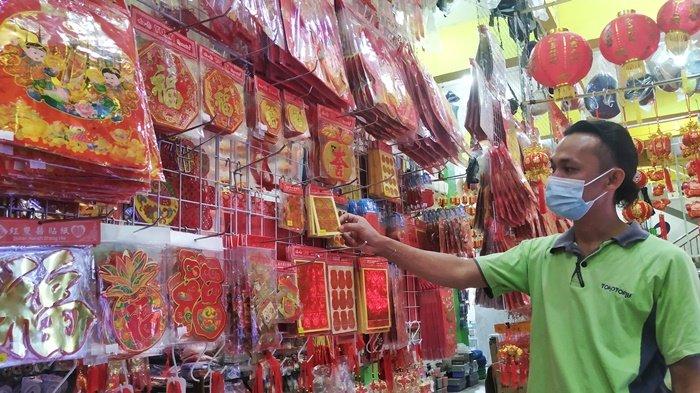 Penjual di Tanjungpandan saat sedang menghias aksesoris Imlek di Toko Tomy, Senin (8/2/2021)