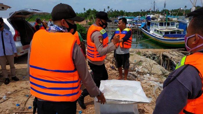 Pihak kepolisian saat mengawal pendistribusian logistik pilkada ke pulau