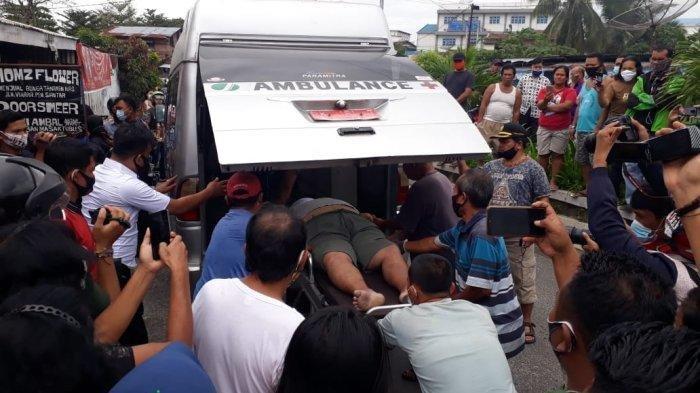 Personel kepolisian dari Polsek Siantar Selatan mengevakuasi jenazah Deny Siregar ke Ambulans RSUD Djasamen Saragih, Selasa (5/1/2021)