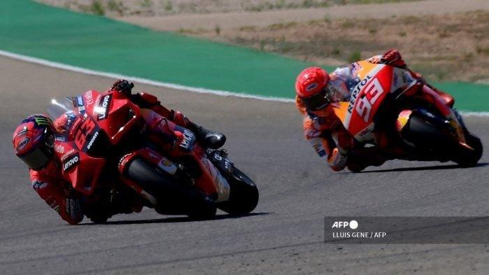 Pembalap Italia Francesco Bagnaia mengendarai motornya di depan 93 pembalap Honda Spanyol Marc Marquez (kanan) selama Moto Grand Prix Aragon di sirkuit Motorland di Alcaniz pada 12 September 2021. (LLUIS GENE / AFP)