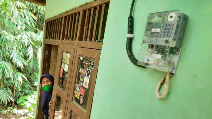 Yoyoh (50) saat menunjukan meteran listrik yang sudah terpasang di rumahnya