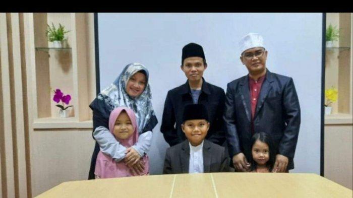 Muhamad Najro Adlani, santri berusia 12 tahun yang berhasil menjadi juara 3 perlombaan Musabaqoh Internasional Tuhan An-Nur Qatar yang digelar secara virtual berfoto dengan orang tuanya.