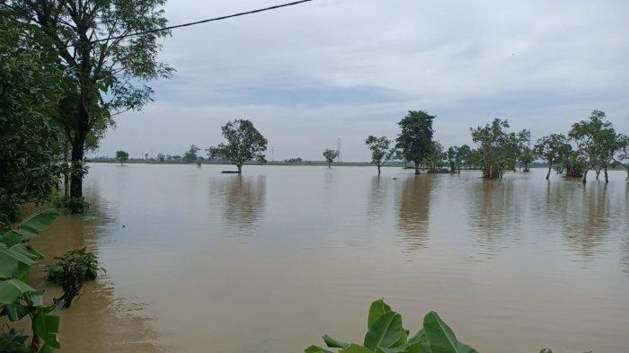 Polisi saat membantu warga yang terdampak banjir akibat luapan Sungai Jati Pari di Desa Jengkok Blok Pondok Asem, Kecamatan Kertasemaya, Kabupaten Indramayu, Rabu (6/1/2021).