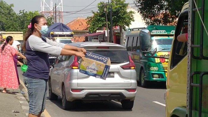 Warga yang merupakan korban banjir terpaksa mengemis di Jalur Pantura di Kecamatan Losarang, Kabupaten Indramayu, Kamis (11/2/2021).