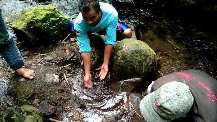 Musladi (47), warga Blok Rebo, Desa Payung, Kecamatan Rajagaluh, Kabupaten Majalengka saat menunjukkan sumber air hangat di aliran Sungai Cingenge di kaki gunung CiremaiÂ