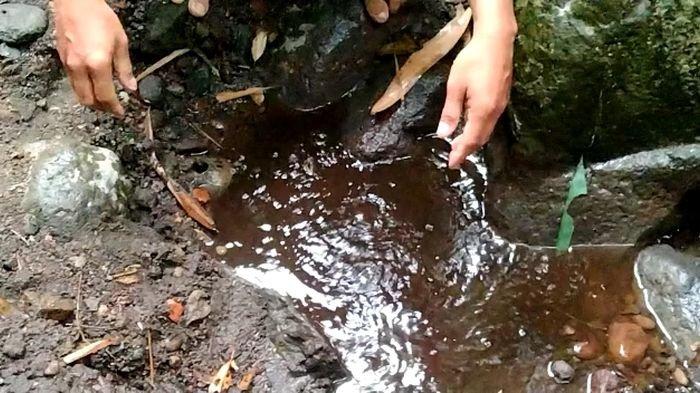 Musladi (47), warga Blok Rebo, Desa Payung, Kecamatan Rajagaluh, Kabupaten Majalengka saat menunjukkan sumber air hangat di aliran Sungai Cingenge di kaki gunung Ciremai,