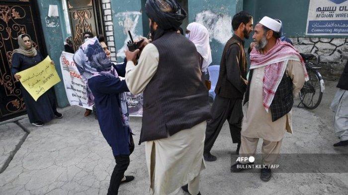 Seorang perempuan anggota demonstran bertengkar dengan Taliban dalam demonstrasi yang digelar di sekolah di Kabul, Afghanistan, pada 30 September 2021. Para perempuan itu berdemonstrasi menuntut supaya murid putri boleh kembali lagi ke sekolah.