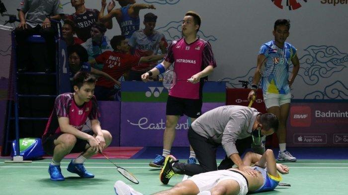 Pebulutangkis ganda putra Indonesia, Yeremia Erich Yoche Yacob Rambitan, tergeletak di lapangan karena mengalami cedera saat bertanding di babak perempatfinal Indonesia Open 2022 di Istora Senayan, Jakarta, 17 Juni 2022.