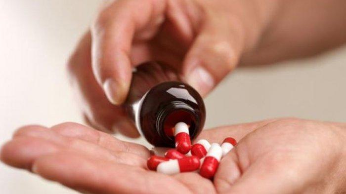 ilustrasi seseorang mengonsumsi obat Covid