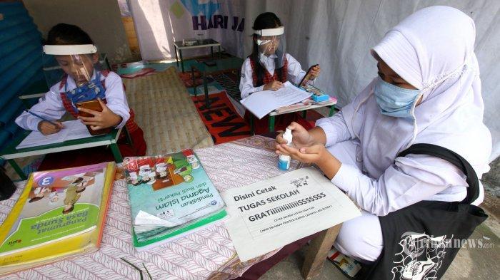 Sejumlah siswa mengenakan masker dan pelindung wajah mengerjakan tugas dari sekolah saat mengikuti Pembelajaran Jarak Jauh (PJJ) di Warnet Covid-19 RW 09, Kelurahan Lingkar Selatan, Kecamatan Lengkong, Kota Bandung, Jawa Barat, Senin (10/8/2020). Fasilitas warung internet gratis dengan menerapkan protokol kesehatan ini dihadirkan untuk membantu para siswa dalam mengikuti PJJ, sehingga para orang tua siswa tidak perlu lagi khawatir soal kuota internet.