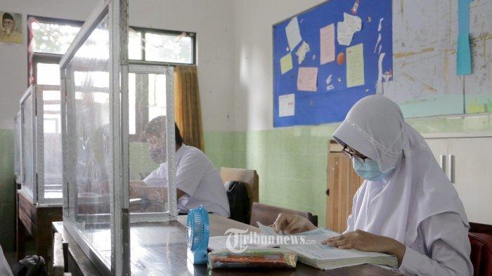 Siswa kelas VII SMP N 9 Semarang sedang mengikuti proses belajar tatap muka di minggu terakhir sebelum libur Hari Raya Idul Fitri, Selasa (4/5/21). Dalam proses pembelajaran di bagi menjadi dua tahap yaitu setiap hari Senin dan Selasa yang mengikuti belajar tatap muka langsung di sekolah adalah siswa nomer absen 1-16 sedangkan Rabu dan Kamis nomer absen siswa 17-32. Untuk minggu ke dua nanti akan di balik biar semua merasakan belajar tatap muka di kelas sedangkan yang lainnya akan belajar online melalui live melalui aplikasi sekolah. Untuk prosoes pembelajaran dimulai pukul 08.00 WIB hingga pukul 10.00 WIB baik yang di sekolah maupun yang daring di rumah.