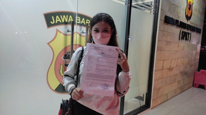 Natalie Azata Sania saat memperlihatkan bukti laporan yang diterimanya di Polres Garut