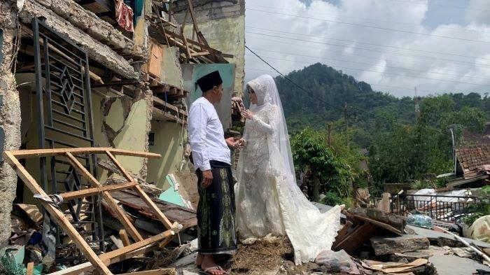 Muhamad Nurdin dah Nida Khovia Sykur saat berfoto di rumah ambruk yang seharusnya dijadikan tempat resepsi pernikahannya, di Kampung Barulega, Desa Cirumput, Kecamatan Cugenang, Kabupaten Cianjur, Minggu (4/12/2022).