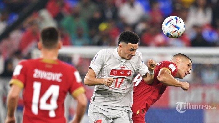 Penyerang Timnas Swiss, #17 Ruben Vargas (tengah) berebut bola atas dengan bek Timnas Serbia, #04 Nikola Milenkovic (kanan) dalam laga sepak bola Grup G Piala Dunia 2022 Qatar antara Serbia melawan Swiss di Stadion 974, di Doha, Qatar, Jumat (2/12/2022) waktu setempat. AFP/FABRICE COFFRINI