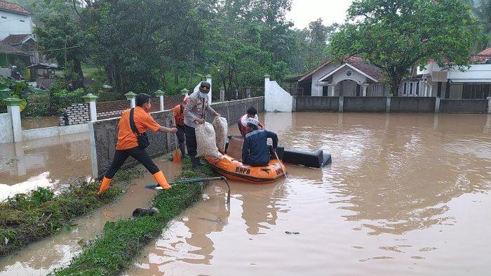BPBD dan Polsek Mande membantu evakuasi warga yang rumahnya terendam banjir, Rabu (28/4/2021) pagi.