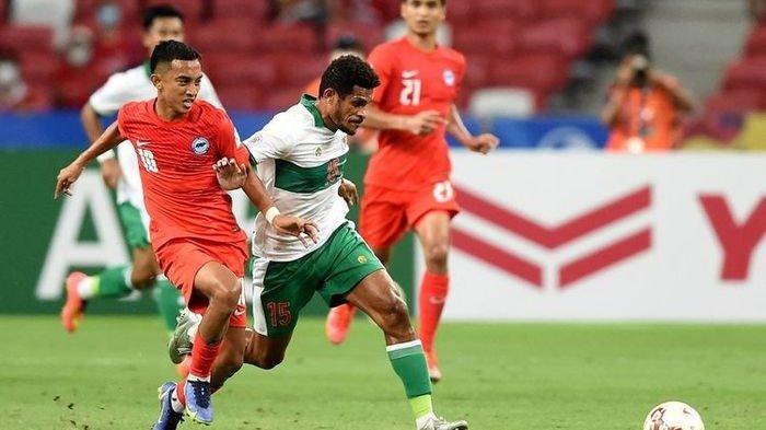 Gelandang Indonesia Ricky Richardo Kambuaya (putih hijau) mencoba melewati pemain Singapura pada pertandingan leg pertama semifinal AFF Cup 2020 di National Stadium, Singapura, Rabu (22/12/2021) malam.(AFP/ROSLAN RAHMAN)