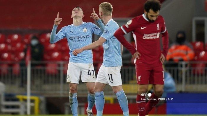 Gelandang Inggris Manchester City Phil Foden (kiri) melakukan selebrasi setelah mencetak gol keempat mereka selama pertandingan sepak bola Liga Utama Inggris antara Liverpool dan Manchester City di Anfield di Liverpool, Inggris barat laut pada 7 Februari 2021. Manchester City memenangkan pertandingan 4-1. TIM KEETON / POOL / AFP