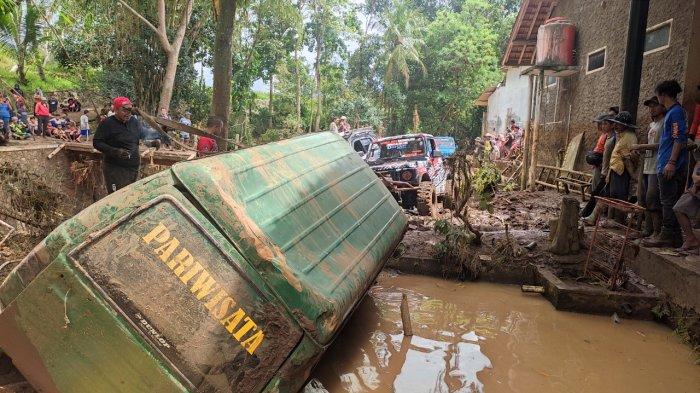 Satu unit mobil milik warga terlempar sejauh 100 meter dari garasi, akibat banjir bandang di Desa Sukawening, Kecamatan Sukawening, Kabupaten Garut, Minggu (28/11/2021)