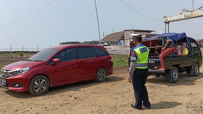 Petugas saat memutarbalikkan kendaraan wisatawan di Pantai Karangsong Indramayu, Minggu (23/5/2021).