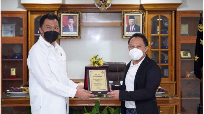 Kepala Divisi TIK Polri Irjen Pol Slamet Uliandi (kiri) menyerahkan penghargaan khusus kepada Telkom atas kontribusi perusahaan dalam mendukung kegiatan vaksinasi dan berbagai aktivitas kepolisian. Penghargaan ini diterima langsung oleh Direktur Enterprise & Business Service Telkom Edi Witjara (kanan) di Jakarta pada Rabu (13/10).
