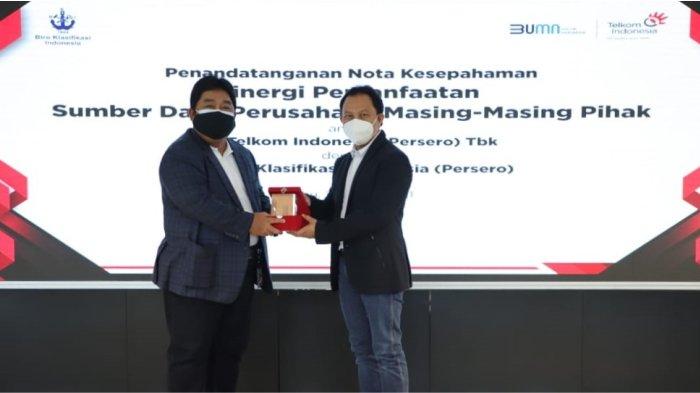 Direktur Enterprise & Business Service Telkom Edi Witjara (kanan) menyerahkan cindera mata kepada Direktur Pengembangan Sumber Daya BKI Saifudin Wijaya usai penandatanganan Nota Kesepahaman tentang Sinergi Pemanfaatan Sumber Daya Perusahaan yang bertempat di Jakarta (24/3).