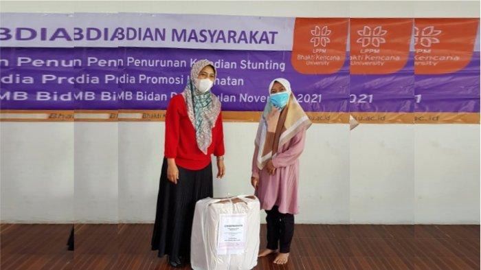 Ketua tim Pengmas, Supriyatni Kartadarma, SKM., M.KM dengan penyerahan cinderamata