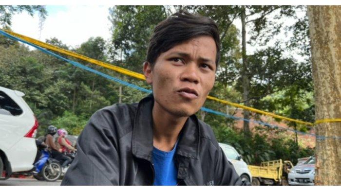 Ade menunggu Tim SAR Gabungan mencari jasad ibu dan adiknya di longsoran kawasan Warung Sate Sintha, Jalan Raya Cipanas-Puncak, Jawa Barat, Senin (28/11/2022).