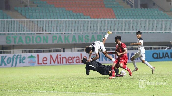 Pemain Tim Nasional (Timnas) Indonesia Muhammad Nabil Asyura berebut bola dengan pemain Timnas Guam Chargualaf pada babak kualifikasi AFC U17 Asian Cup 2023 di Stadion Pakansari, Bogor, Jawa Barat, Senin (3/10/2022). Pada pertandingan babak pertama tim asuhan Bima Sakti unggul 7-0 dari Timnas Guam. Tribunnews/Jeprima (Tribunnews/JEPRIMA)