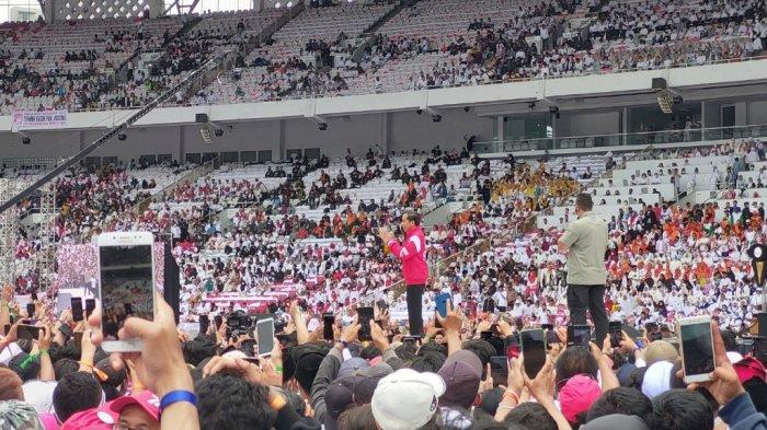 Momen Presiden Jokowi hadiri acara Nusantara Bersatu di GBK, Jakarta, Sabtu (26/11/2022). Mengenakan jaket merah bertuliskan G20, Jokowi juga melemparkan jaket tersebut ke salah satu relawan saat berad di atas panggung.