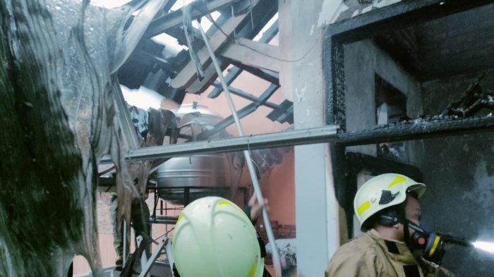 Personel Damkar Jakarta Timur saat proses pemadaman api pada rumah di Jalan Kelapa Hibrida, Pondok Kelapa, Duren Sawit, Jumat (22/4/2022)